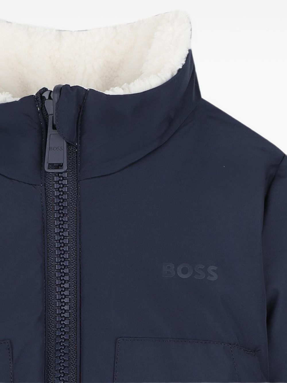 Reversible piumino. One side in sherpa con chiusura con zip, boss badge sul chest, e two side tasche. Other side in nylon con chiusura con zip, boss logo sul chest, e two patch tasche sul davanti. J53505 120 BOSS KIDSWEAR