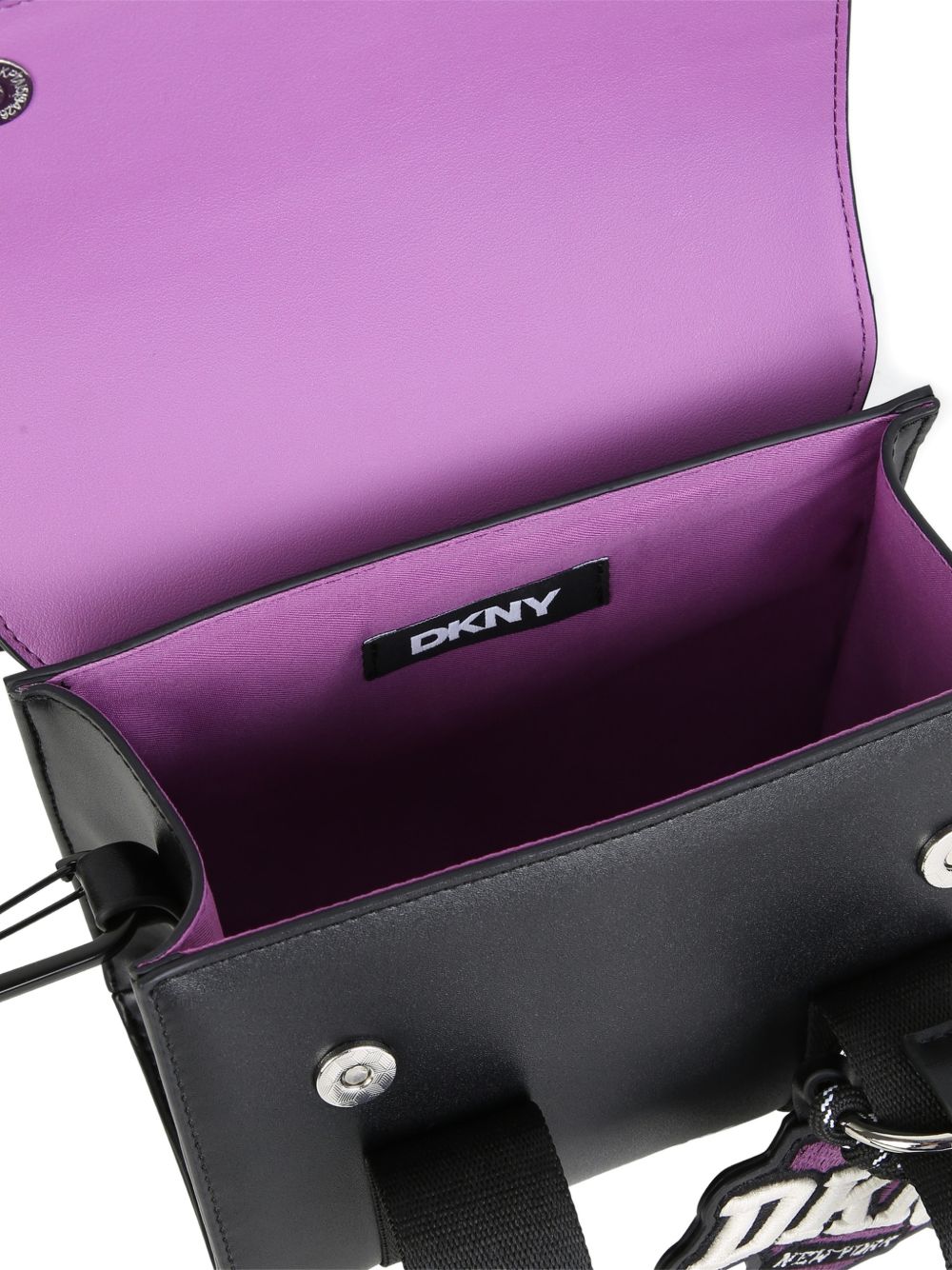 Handbag in simili con fantasia charms e stampa on davanti. Magnetic chiusura. Two possible ways to carry this bag : removable strap e handles. Colored fodera. Dimensions : 14.5x17.5x7cm. D62932 09B DKNY KIDS