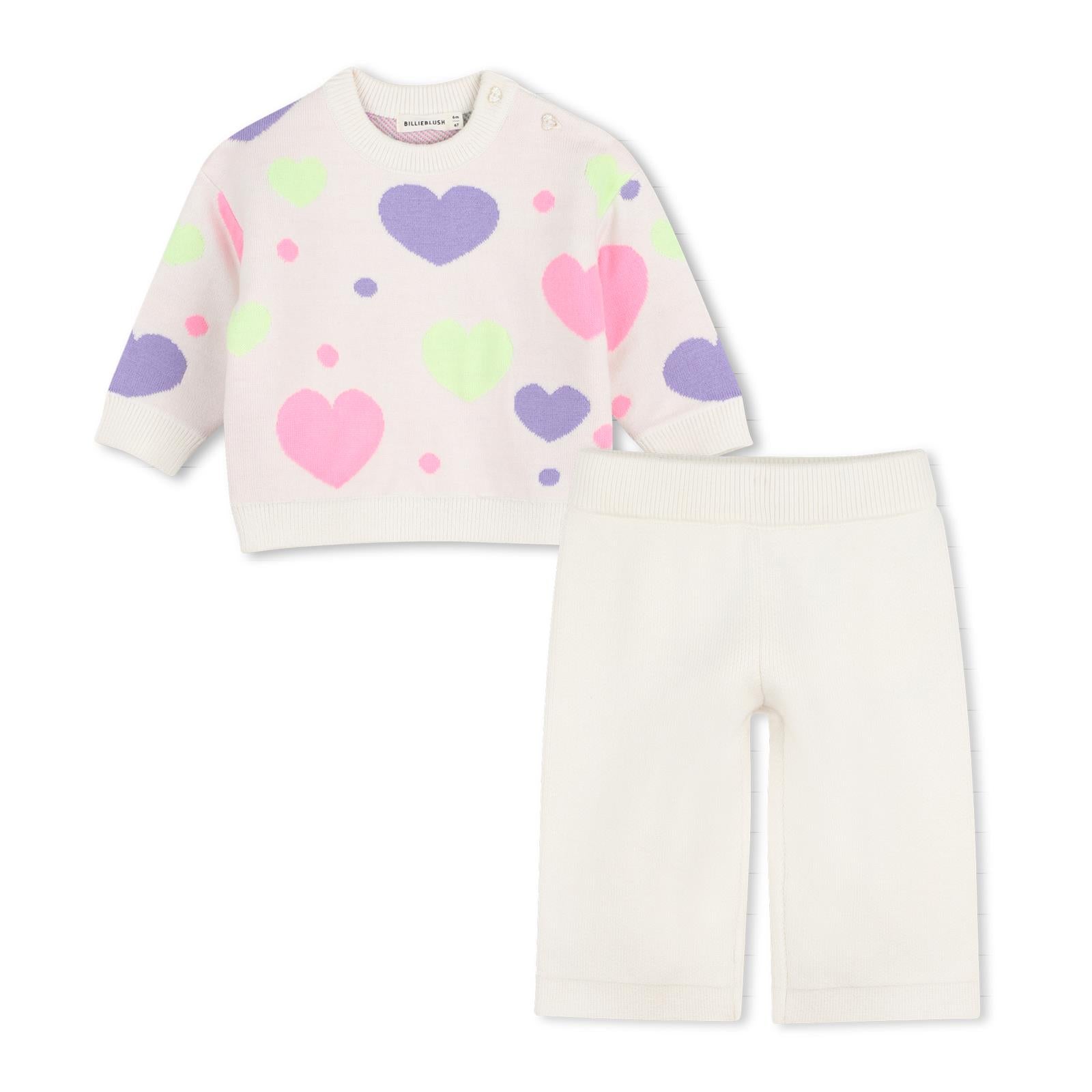 Completo in maglia due pezzi con maglione a maniche lunghe con cuori in jacquard, scollo tondo, chiusura con bottoni sulla spalla. Ampio pantaloni in maglia, vita elastica. U22611 121 BILLIE BLUSH KIDS