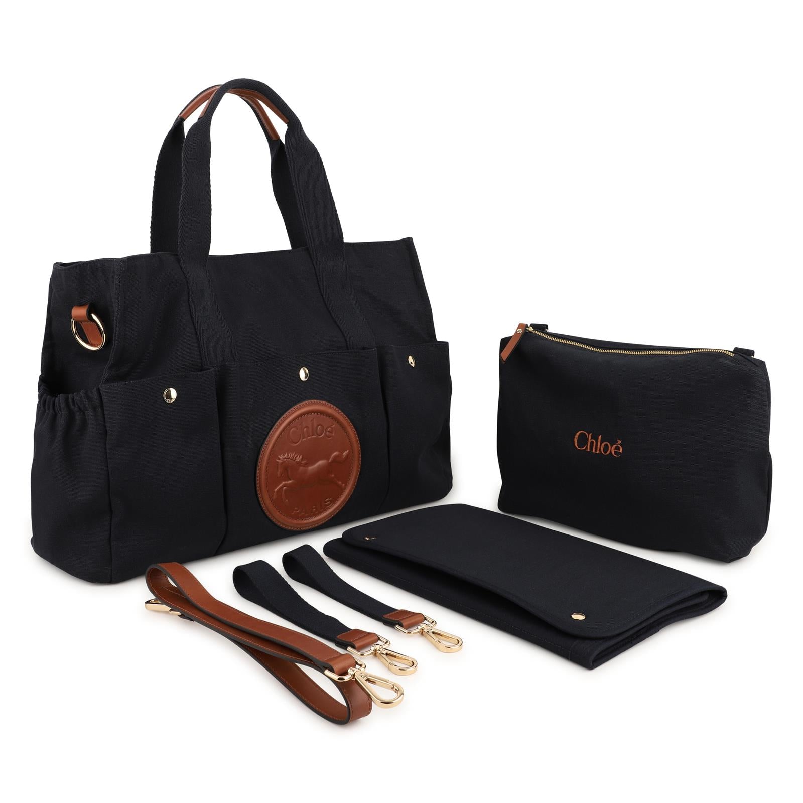 Canvas changing bag, containing cotton from organic farming, goat leather strap e details, davanti e sides multipockets con snaps, cotton twill fodera, patch in goat leather con chloe horse embossed. Dimensions: w41xh33xd15cm. Strap length: 83cm. Sol C21387 859 CHLOE KIDS 