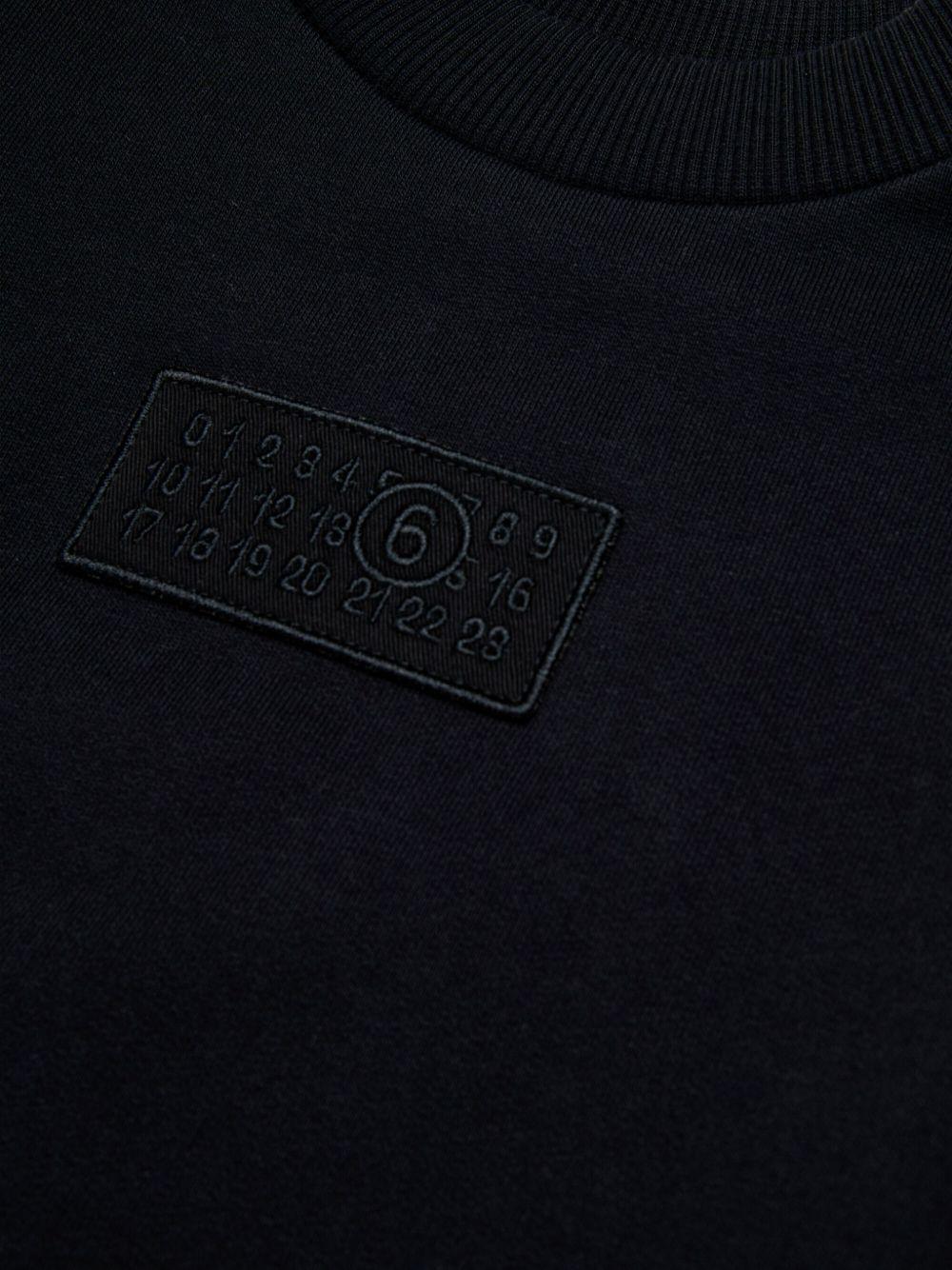 Felpa nera girocollo con applicazione frontale e logo numerico M60904MM04H M6900 MM6 MAISON MARGIELA KIDS 