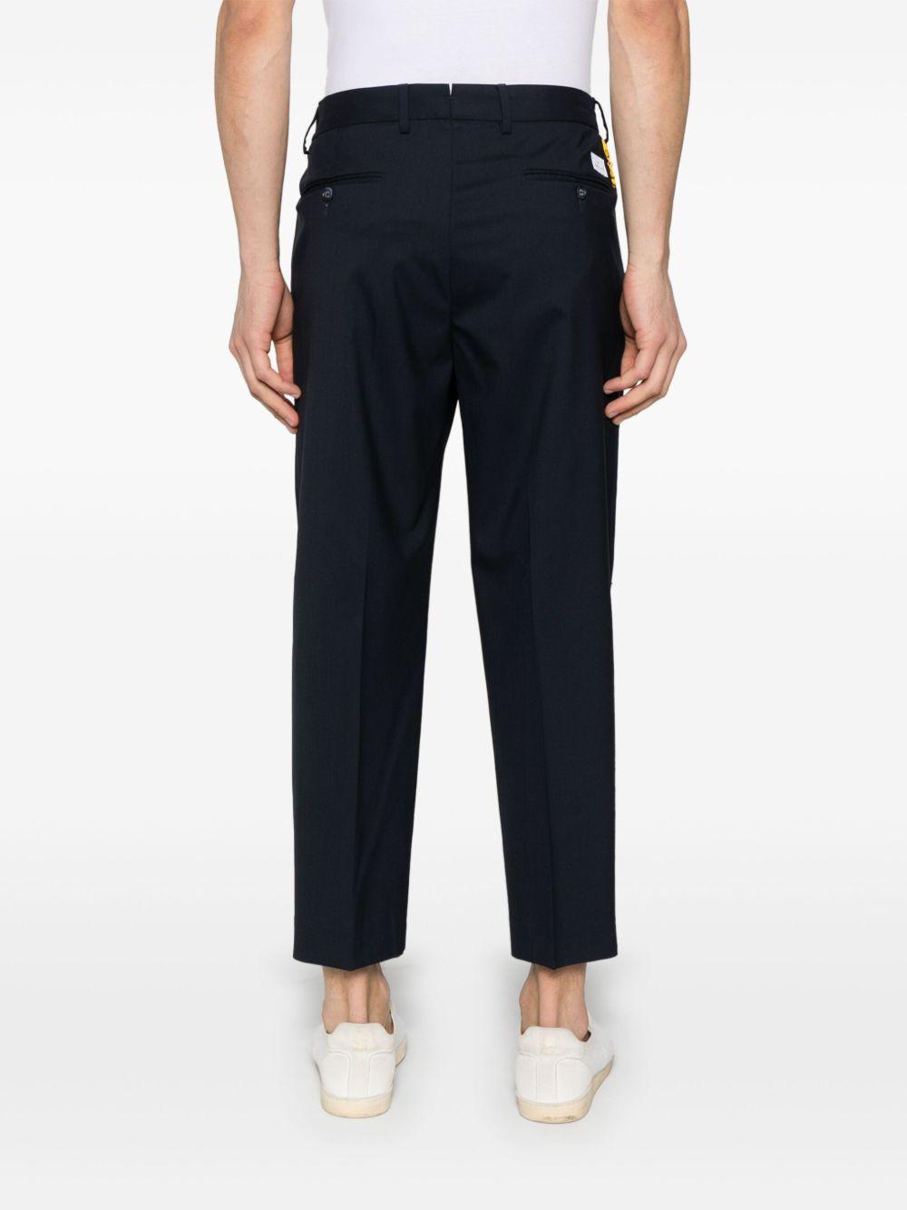 Pantalone blu con accessorio logato