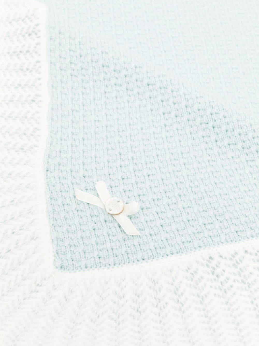 Coperta acqua marina in maglia con orlo a contrasto