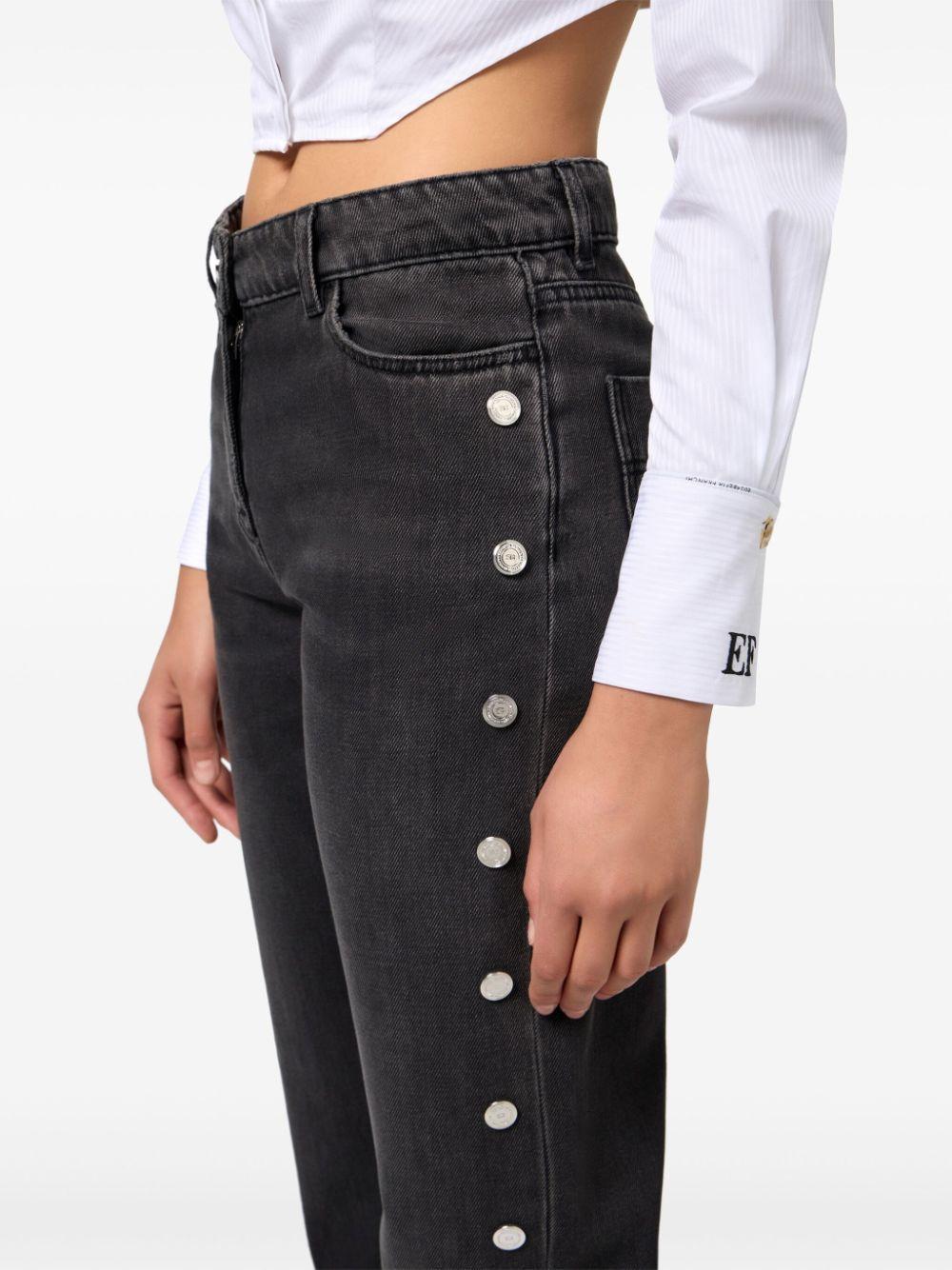 Jeans a gamba ampia nero con bottoni laterali